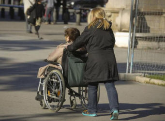una mujer empuja una silla de ruedas