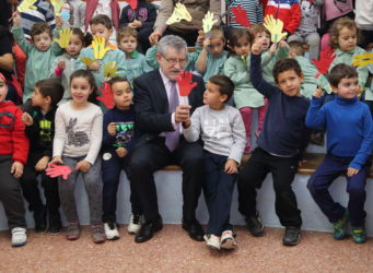 Imagen de un directivo de la Junta con un grupo de niños y niñas