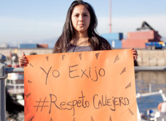 una mujer con una pancarta pidiendo respeto callejero