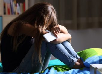 Imagen de una joven de cabello largo con un smartphone en la mano