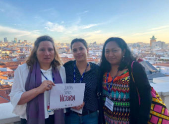 Tres mujeres con el cartel Juntas somos Victoria