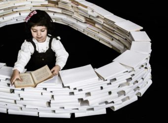 una niña rodeada de libros