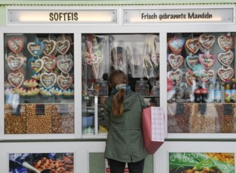 una mujer delante de un escaparate lleno de galletas en forma de corazón