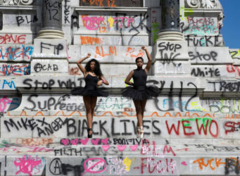 dos bailarinas de color protestan delante de un monumento en Virginia