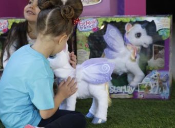 una niña juega con un unicornio