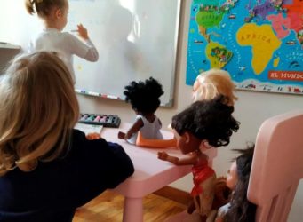 niñas en una escuela jugando con muñecas