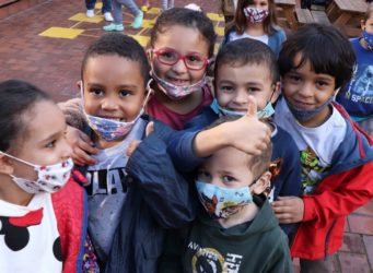 un grupo de niños y niñas en una clase con mascarillas