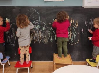 niños y niñas pintan en una pizarra