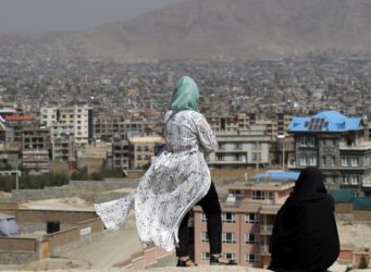 dos mujeres miran Kabul desde un sitio alto